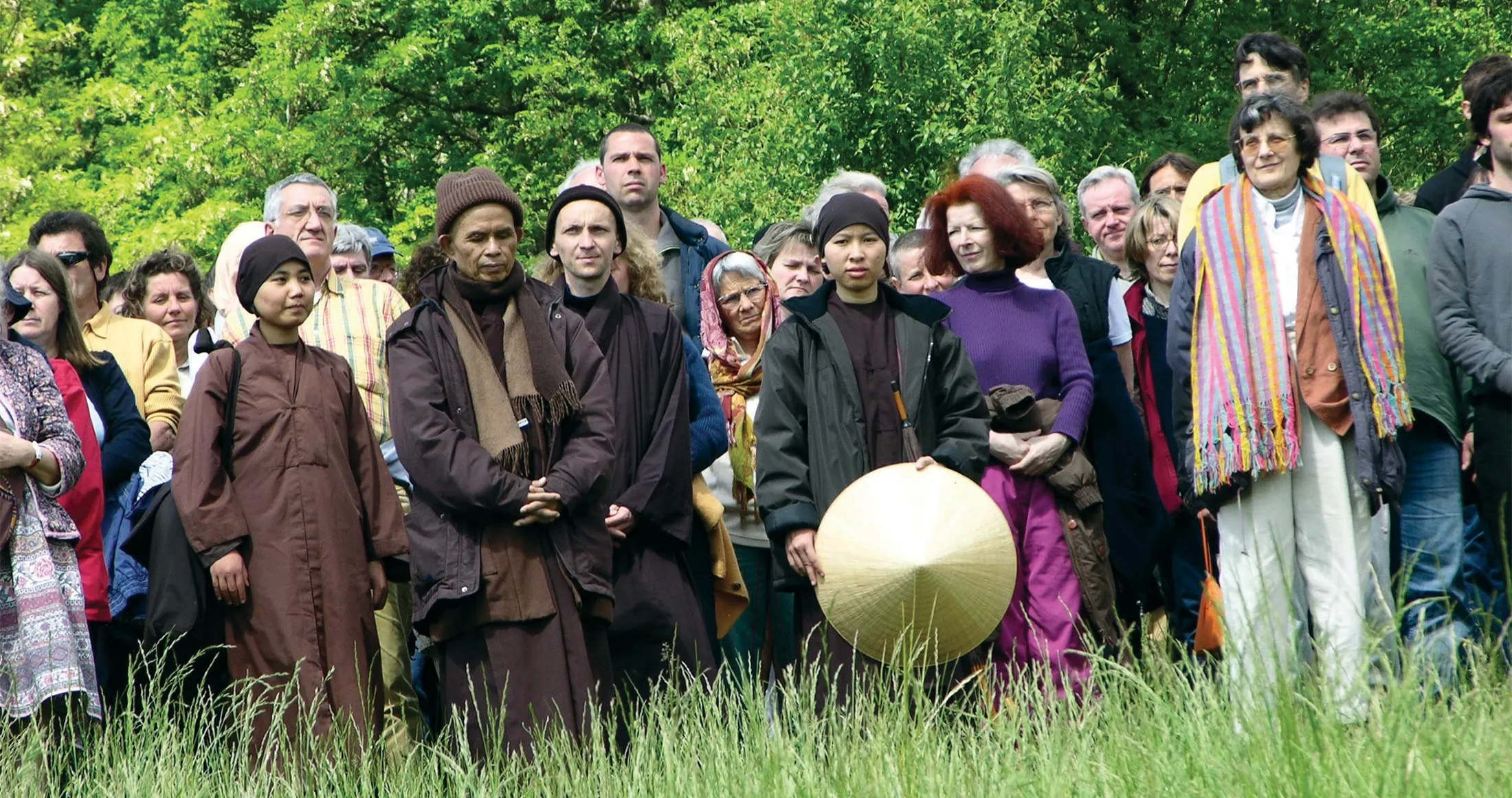 Thich Nhat Hanh et des pratiquants debout dans une prairie