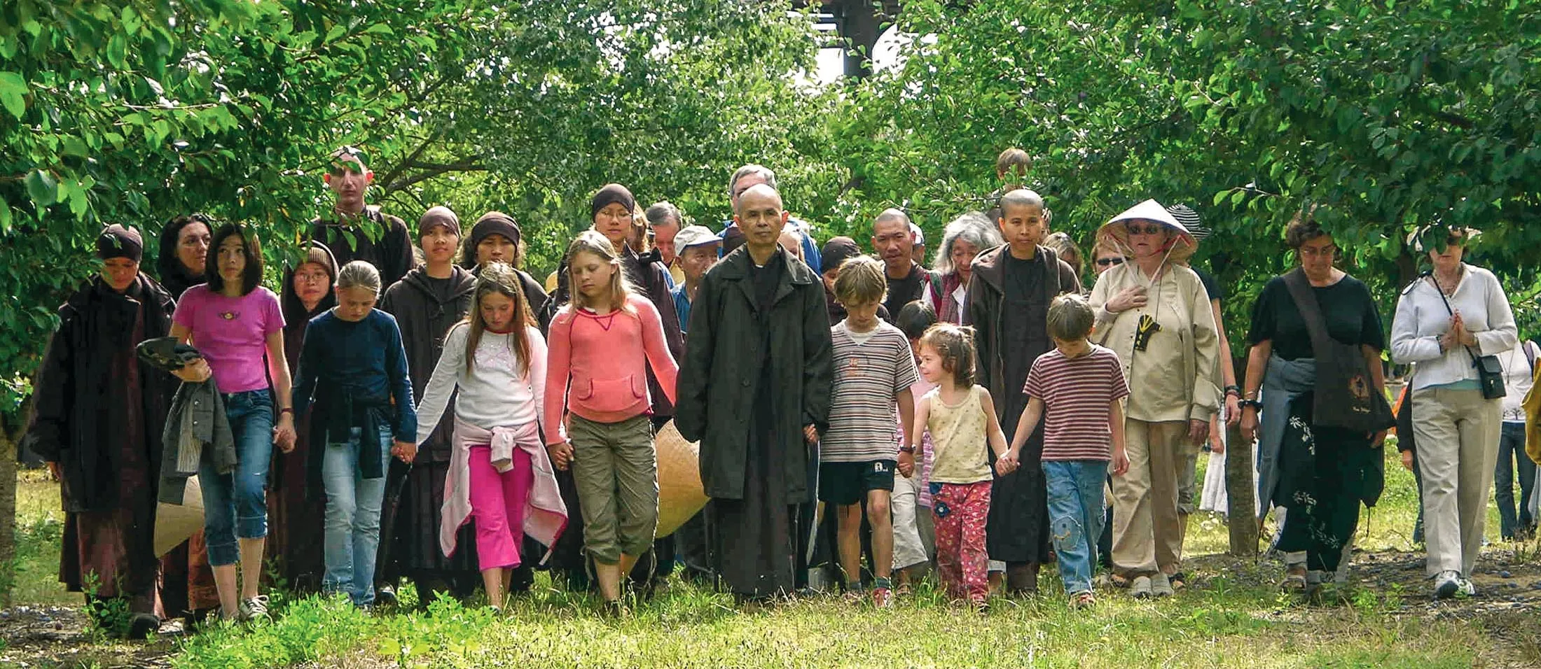 Méditation marchée avec Thich Nhat Hanh, enfants et adultes main dans la main